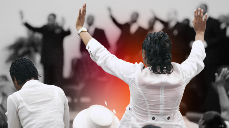 Image of a lady in a white shirt worshiping in church with hands up in praise